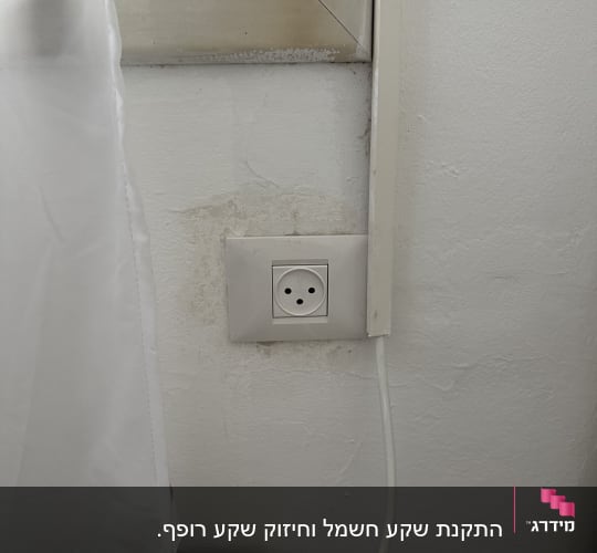שקע חשמל בקיר עם כבל מחובר